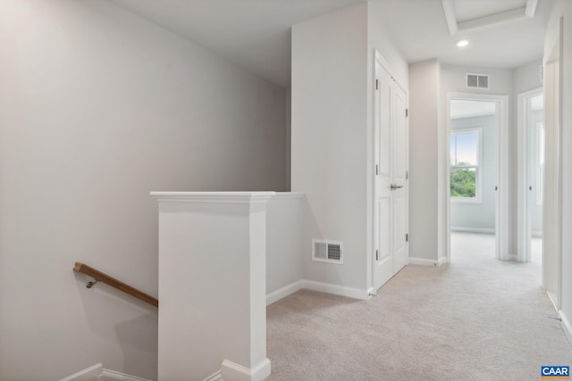 hallway featuring light colored carpet