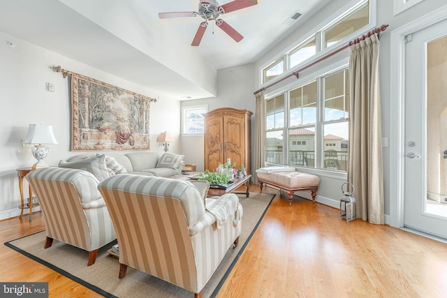 living room featuring a wealth of natural light, ceiling fan, and light hardwood / wood-style flooring