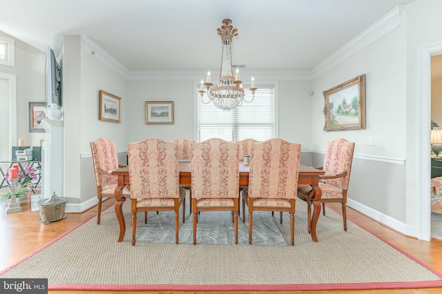 dining space with wood-type flooring, a chandelier, and crown molding