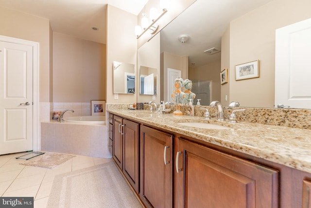 bathroom with tiled bath, tile patterned flooring, and vanity