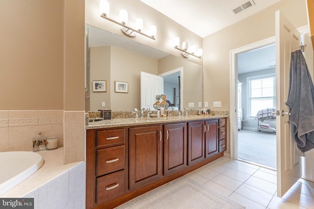 bathroom with vanity, tiled bath, and tile patterned flooring