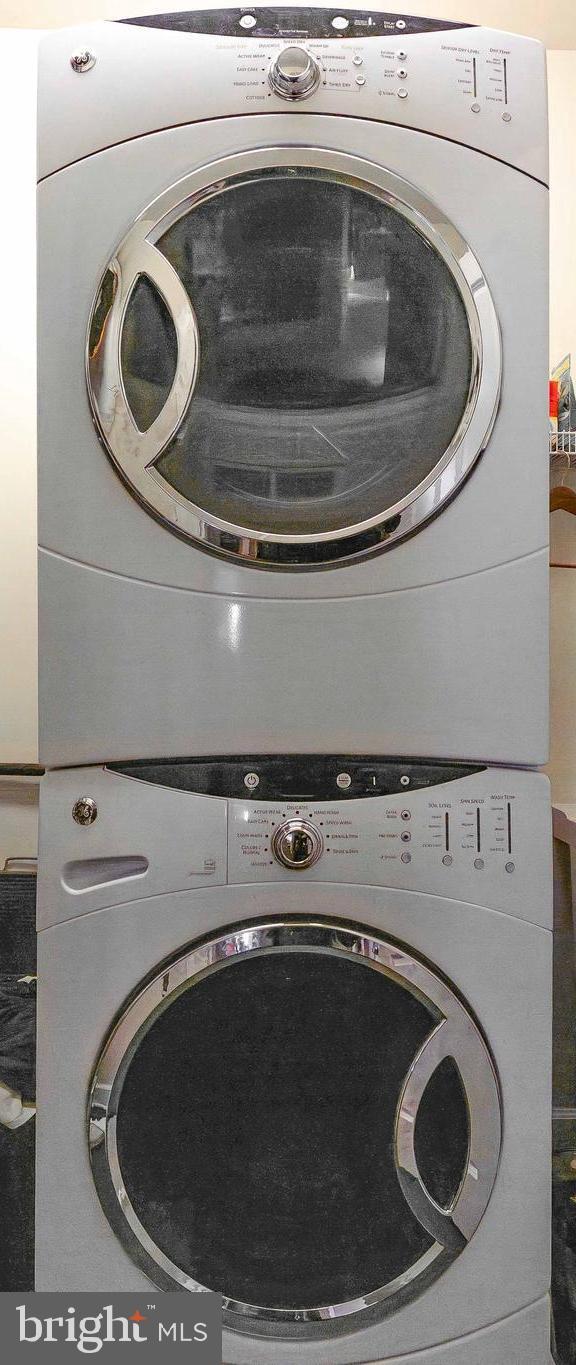 laundry room with stacked washing maching and dryer