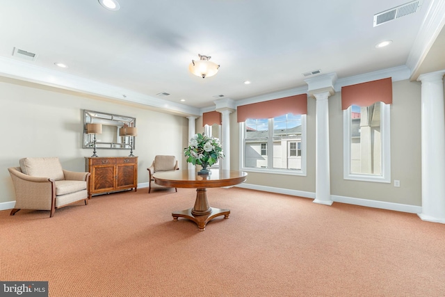 living area with ornate columns, crown molding, and carpet