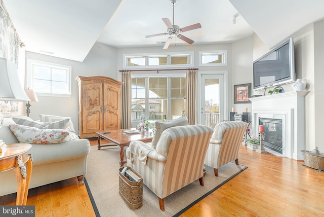 living room with plenty of natural light, light hardwood / wood-style floors, and ceiling fan