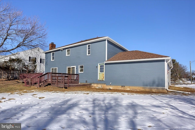 snow covered rear of property with a wooden deck