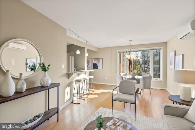 living room featuring a wall mounted AC and light hardwood / wood-style flooring