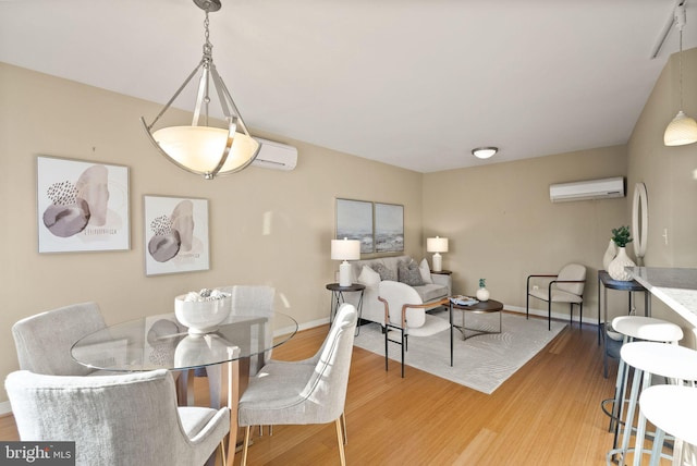 dining area featuring light hardwood / wood-style floors and a wall mounted AC