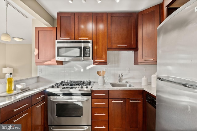 kitchen with sink, light stone counters, stainless steel appliances, and backsplash