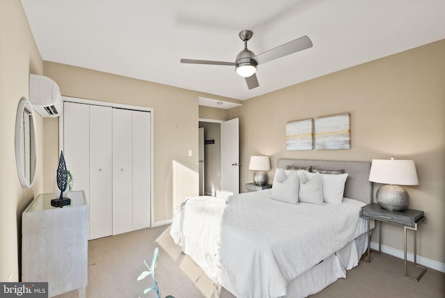 bedroom featuring a closet, ceiling fan, light carpet, and a wall unit AC