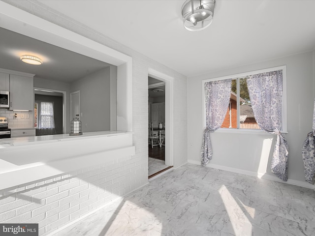 bathroom featuring a healthy amount of sunlight and tasteful backsplash