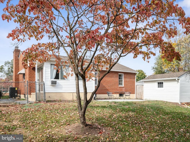 rear view of property featuring cooling unit, a patio, and a yard