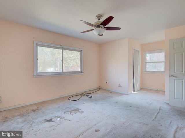 unfurnished room featuring ceiling fan and plenty of natural light