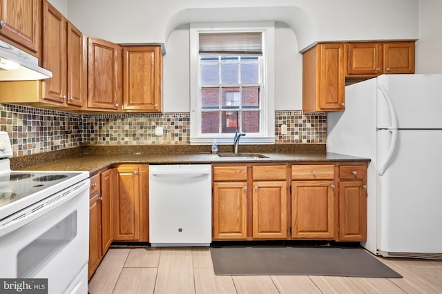 kitchen with white appliances, light hardwood / wood-style flooring, decorative backsplash, and sink