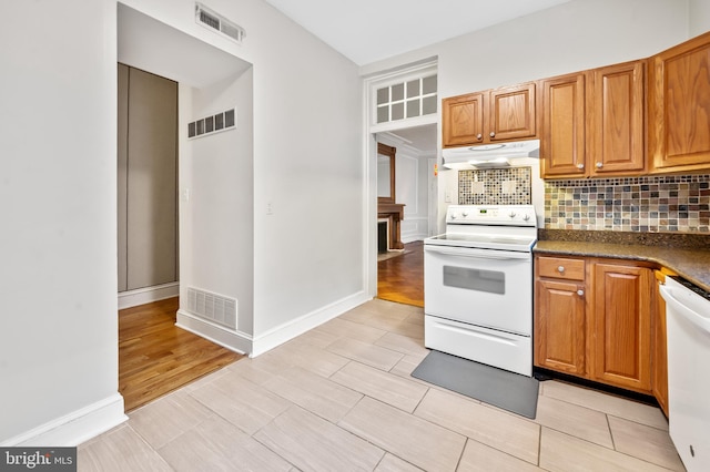 kitchen featuring light hardwood / wood-style floors, backsplash, and white appliances