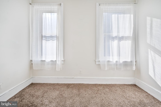 carpeted spare room featuring plenty of natural light