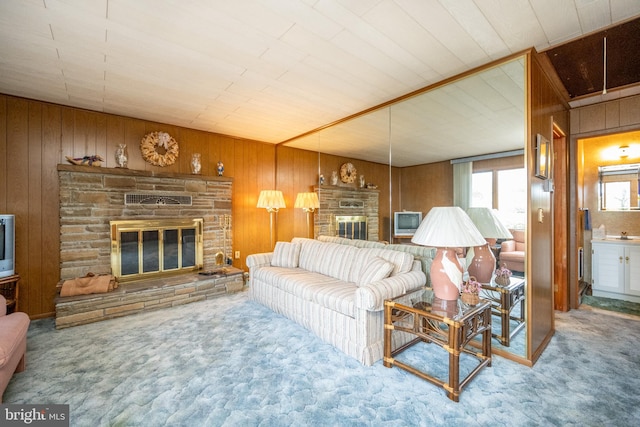 living room featuring wood walls, carpet flooring, and a fireplace