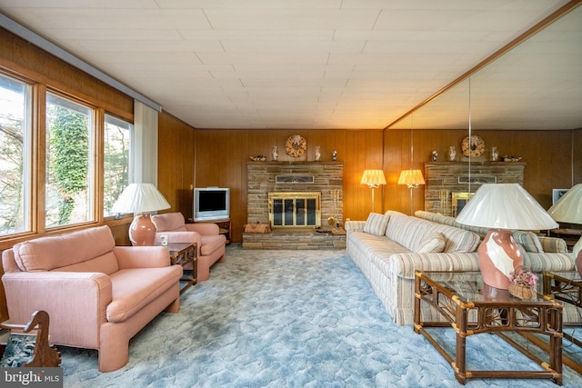 living room featuring carpet, wooden walls, and a fireplace