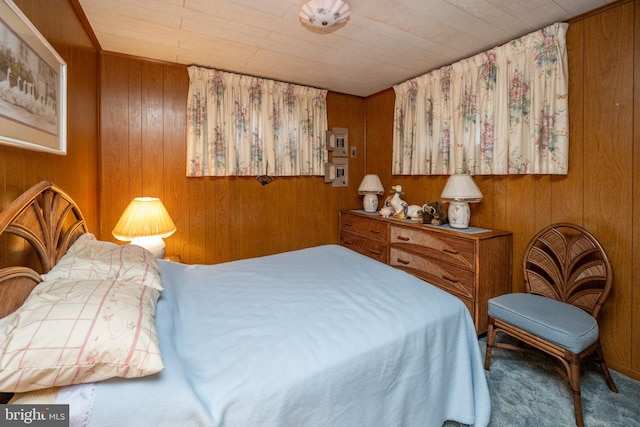 carpeted bedroom featuring wooden walls