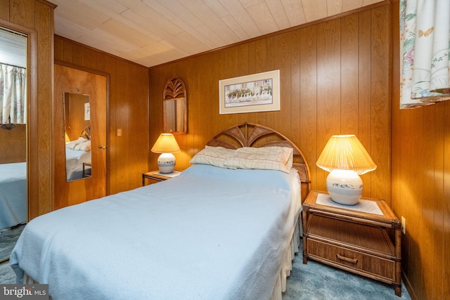 carpeted bedroom featuring wood ceiling and wooden walls