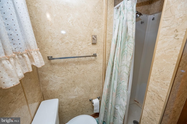 bathroom featuring toilet and a shower with shower curtain