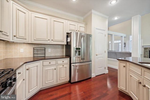 kitchen featuring cream cabinets, tasteful backsplash, dark hardwood / wood-style flooring, appliances with stainless steel finishes, and ornamental molding