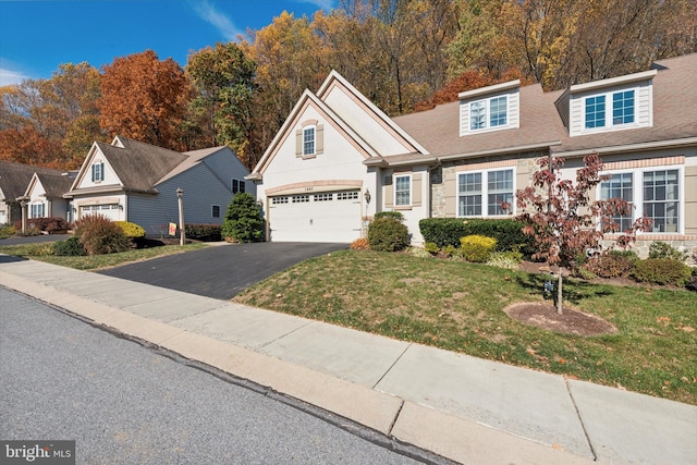 view of front of home with a front yard and a garage