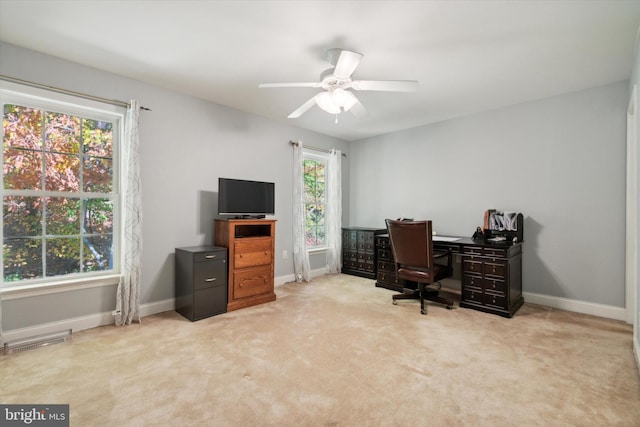 home office featuring light carpet, a wealth of natural light, and ceiling fan