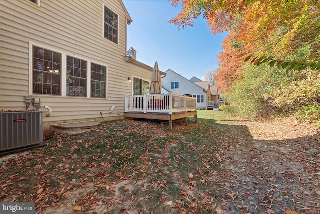 view of yard with central air condition unit and a wooden deck