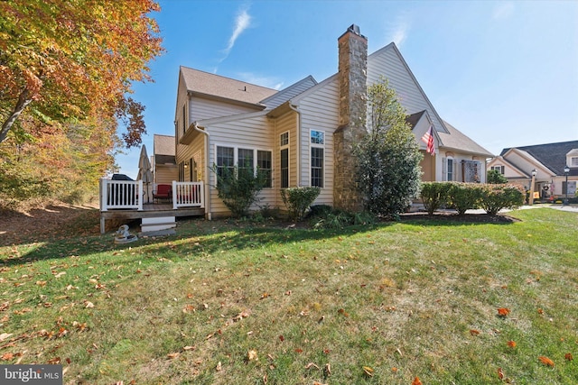 back of property featuring a deck and a yard