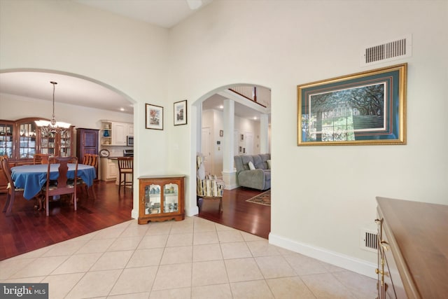 hall with an inviting chandelier, crown molding, and light hardwood / wood-style floors