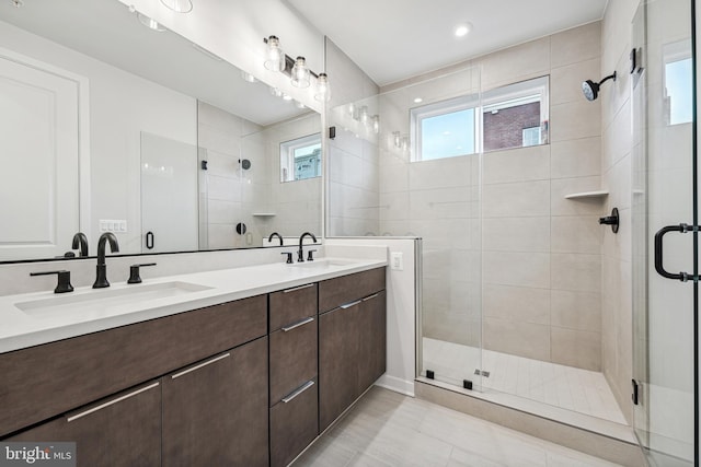 bathroom with vanity, a shower with shower door, plenty of natural light, and tile patterned flooring