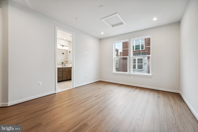 unfurnished room with sink and light hardwood / wood-style flooring