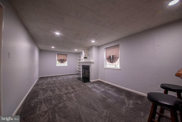 basement with dark carpet and a textured ceiling