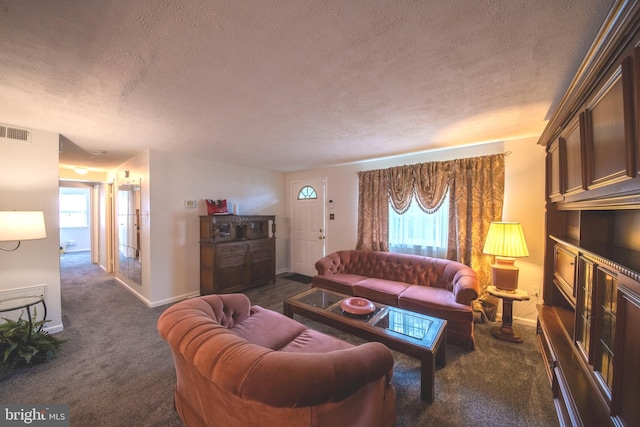 living room with a textured ceiling, a wealth of natural light, and dark carpet