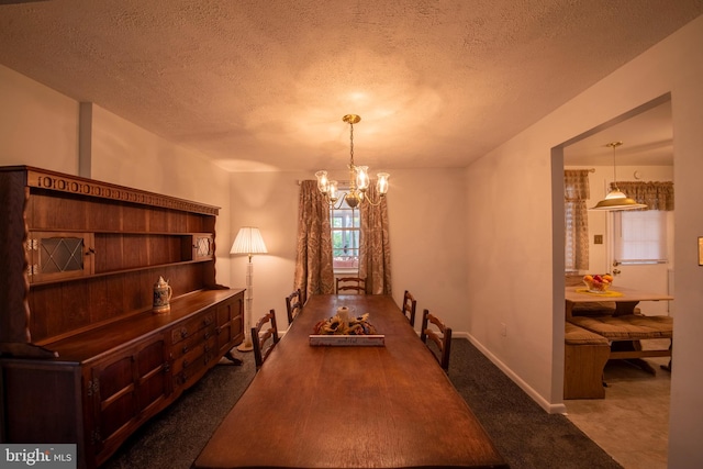 carpeted dining room with a notable chandelier and a textured ceiling