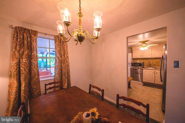 dining area with sink and ceiling fan with notable chandelier