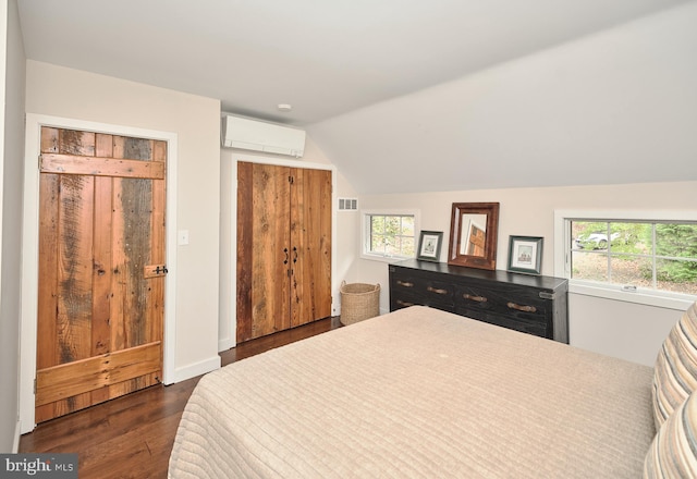 bedroom with dark wood-type flooring, a wall mounted AC, multiple windows, and vaulted ceiling