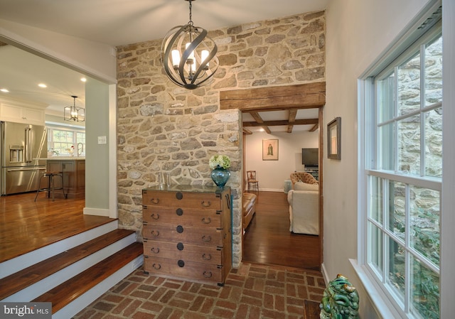 corridor featuring beam ceiling, an inviting chandelier, and dark hardwood / wood-style flooring