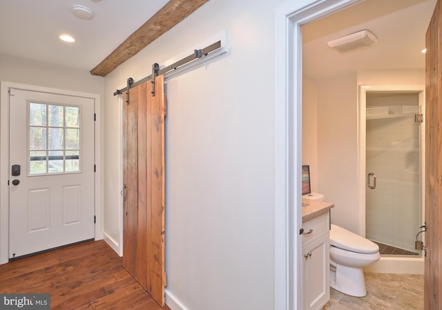 doorway to outside with a barn door and dark wood-type flooring