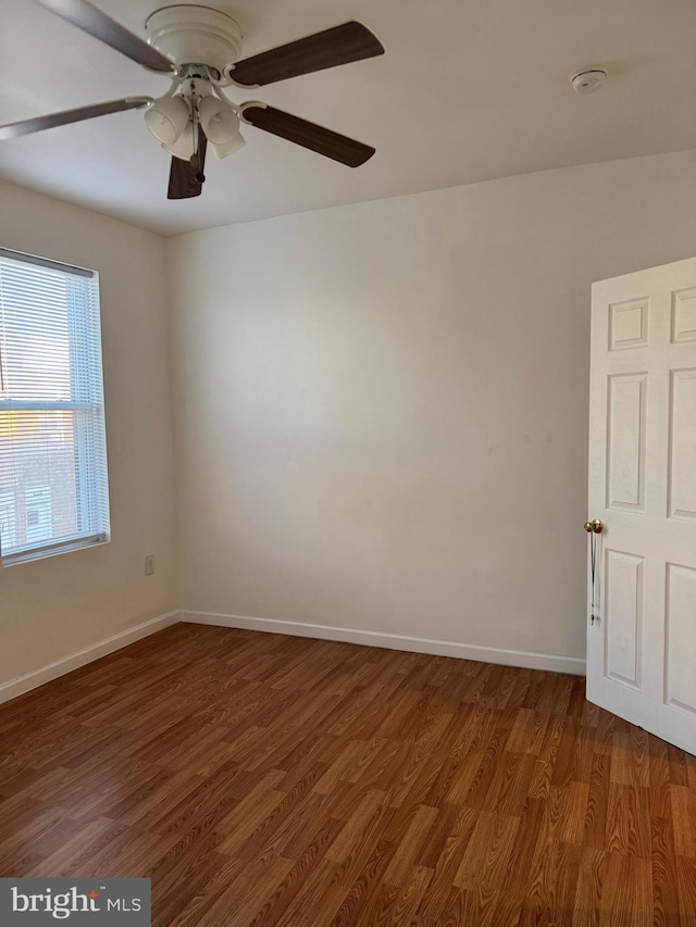 unfurnished room with dark hardwood / wood-style floors and ceiling fan