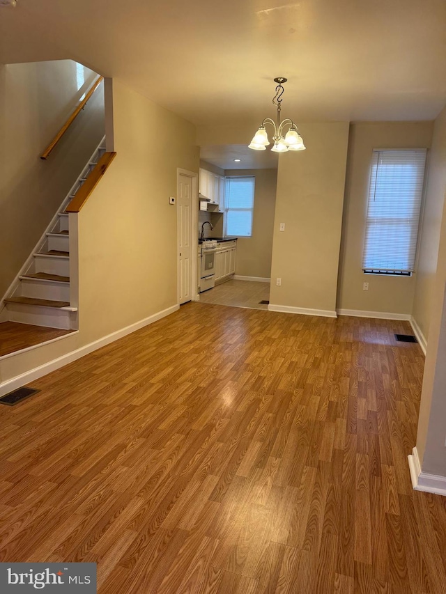 unfurnished living room featuring light hardwood / wood-style floors and a chandelier