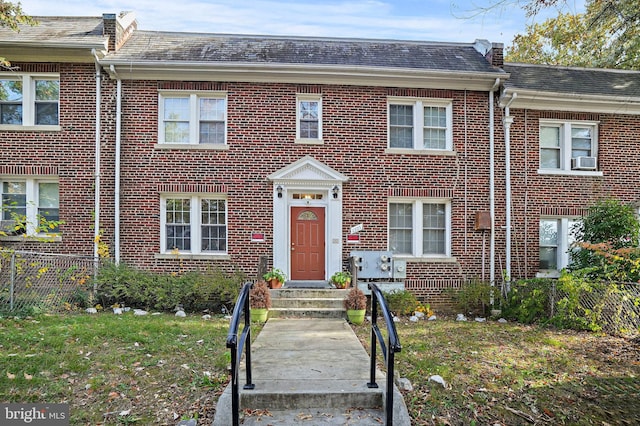 view of front of house with cooling unit and a front yard