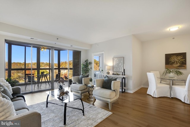 living room with wood-type flooring and ceiling fan