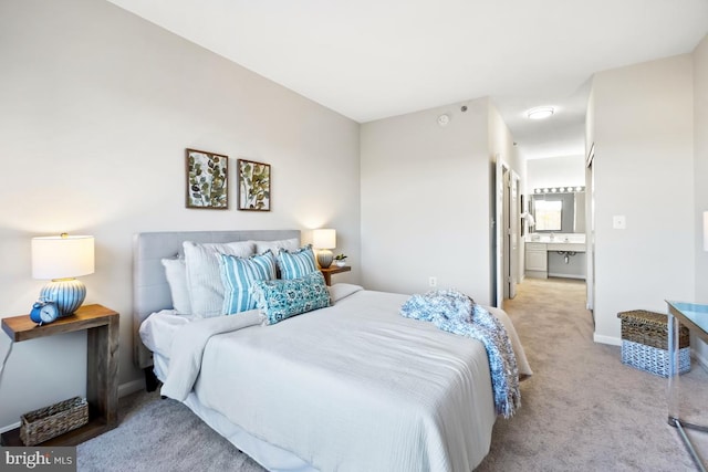 bedroom featuring ensuite bath and light carpet