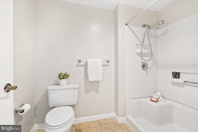 bathroom featuring toilet, tile patterned floors, and tiled shower