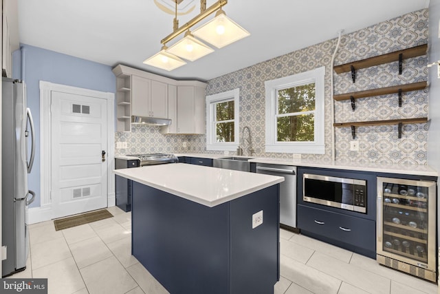 kitchen with wine cooler, a kitchen island, appliances with stainless steel finishes, light countertops, and open shelves