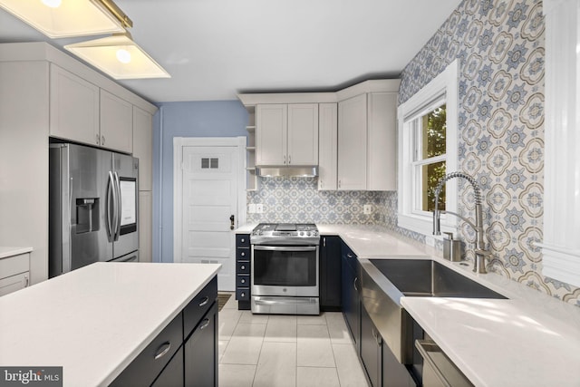 kitchen with stainless steel appliances, light countertops, and gray cabinetry