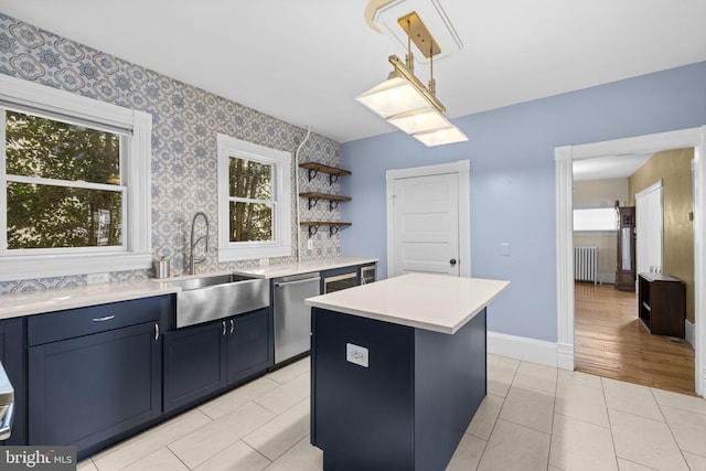 kitchen with radiator, a center island, light countertops, open shelves, and a sink