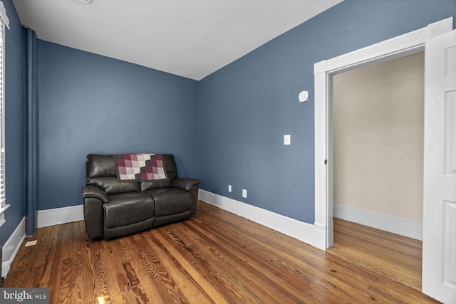 sitting room with baseboards and wood finished floors