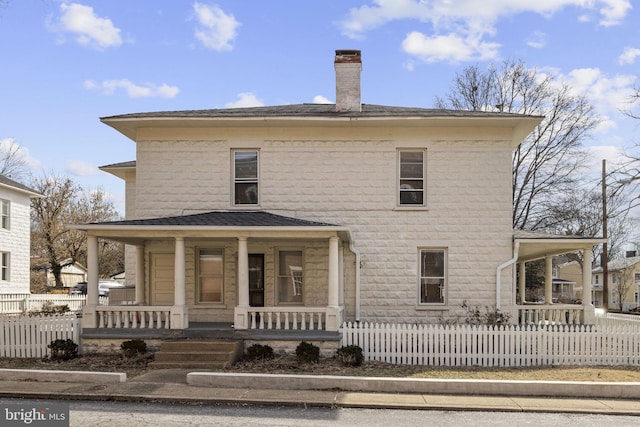 back of house with a fenced front yard, covered porch, and a chimney